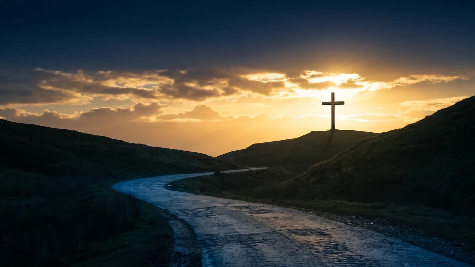 An open road running away from a hilltop cross silhouetted against a golden sunrise sky
